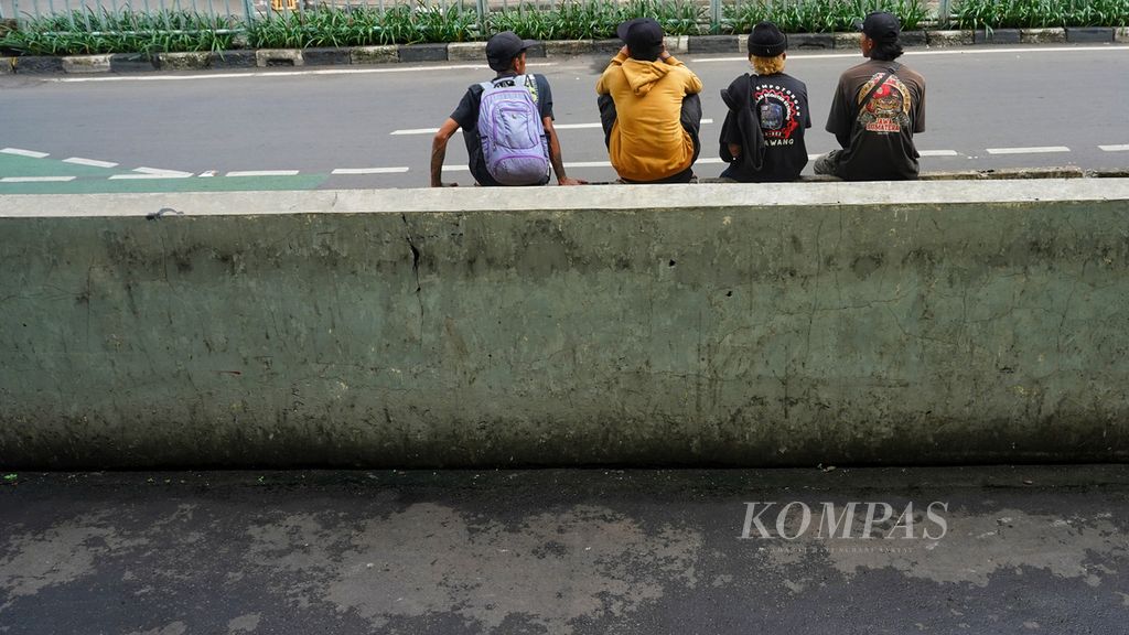 Empat warga duduk di depan Pasar Tanah Abang, Jakarta, yang sepi karena tutup selama libur Lebaran, Jumat (12/4/2024). 