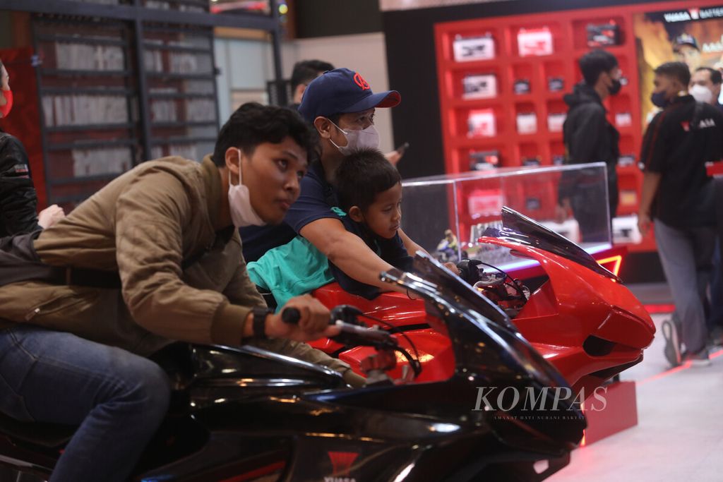 Pengunjung memainkan gim simulasi balap di salah satu stan dalam pameran otomotif Indonesia Motorcycle Show (IMOS) 2022 di Jakarta Convention Center (JCC), Senayan, Rabu (2/11/2022). 