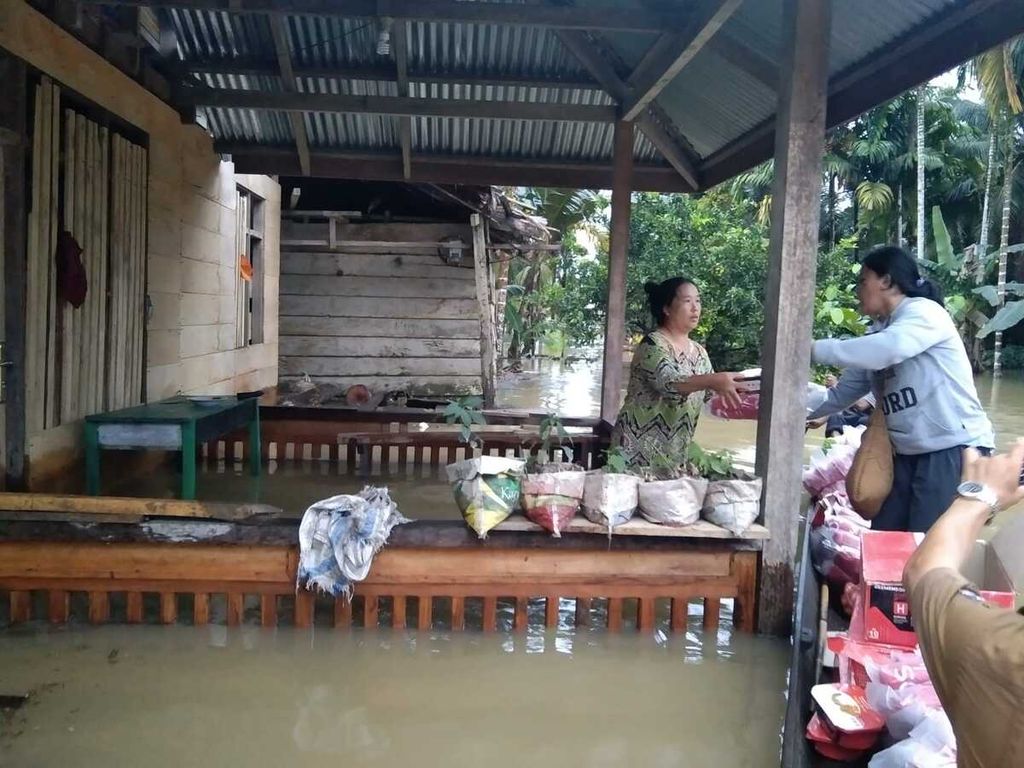 Petugas menyerahkan bantuan logistik dari lumbung sosial kepada warga terdampak banjir di Desa Mongan Poula, Kecamatan Siberut Utara, Kepulauan Mentawai, Sumatera Barat, Senin (14/11/2022).