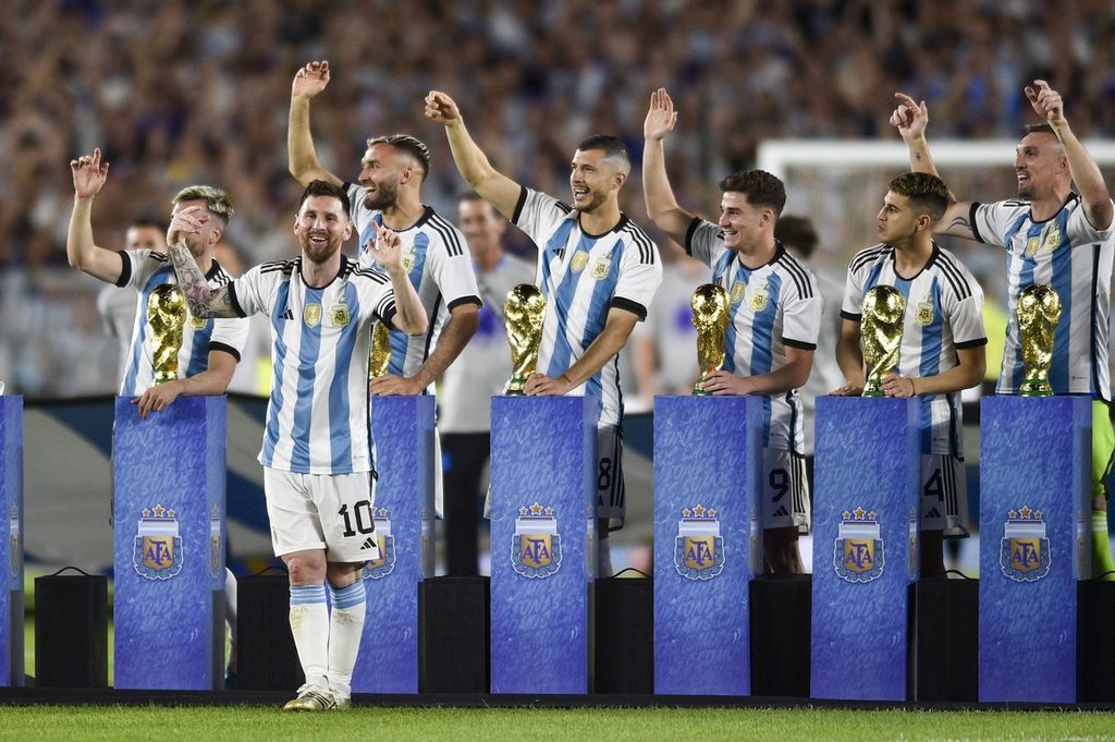 Pemain timnas Argentina Lionel Messi dan rekan-rekannya membawa replika Piala Dunia dalam pesta perayaan keberhasilan mereka untuk menjuarainya, yang digelar usai laga persahabatan melawan Panama, Jumat (24/3/2023) pagi WIB, di Stadion El Monumental, Buenos Aires, Argentina. Argentina menang 2-0 pada laga itu. 