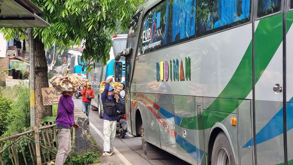 Sejumlah pedagang asongan menanti pintu bus terbuka di tengah kepadatan arus mudik Jalur Nagreg, Kabupaten Bandung, Jawa Barat, Kamis (20/4/2023).