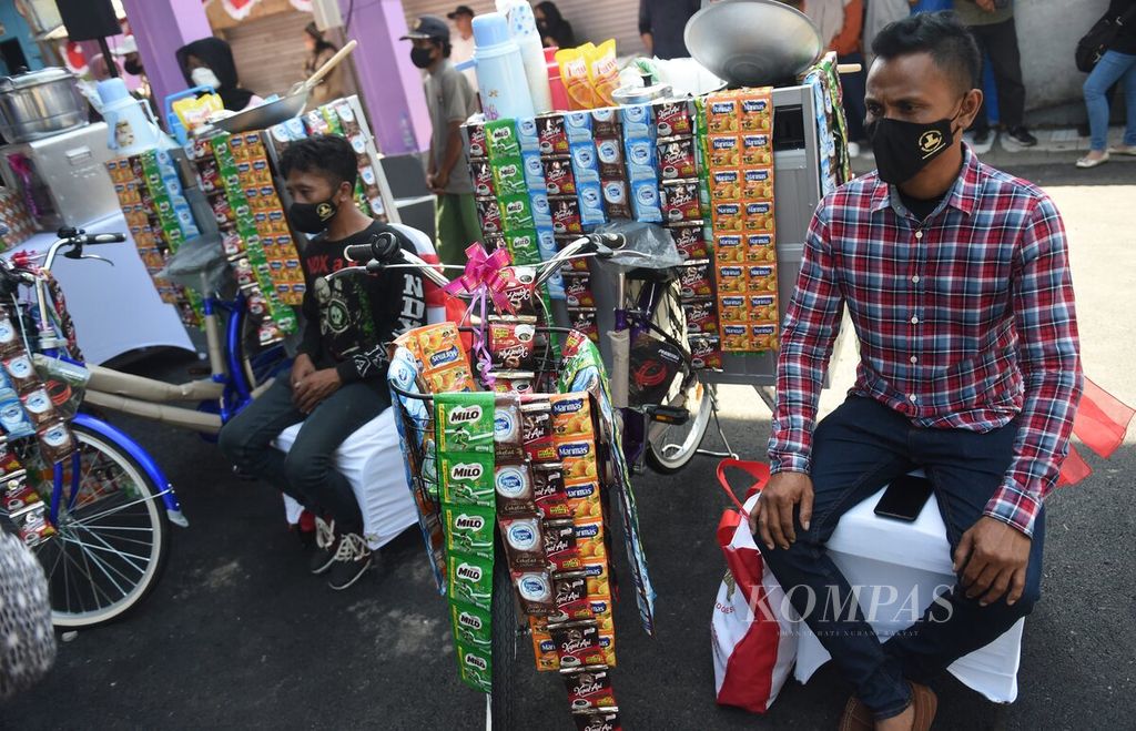 Warga yang mendapat bantuan modal usaha sepeda keliling menunggu kedatangan Presiden Joko Widodo di Pasar Pucang Anom, Kota Surabaya, Jawa Timur, Minggu (21/8/2022).
