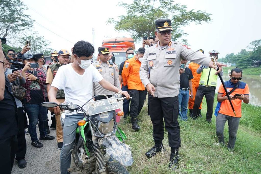 Salah satu pelaku mereka ulang detik-detik saat menceburkan sepeda motor ke Saluran Inpeksi Kalimalang, Kabupaten Bekasi, Senin (6/6/2022) pagi. Kasus kecelakaan lalu lintas ini direkayasa oleh empat pelaku.