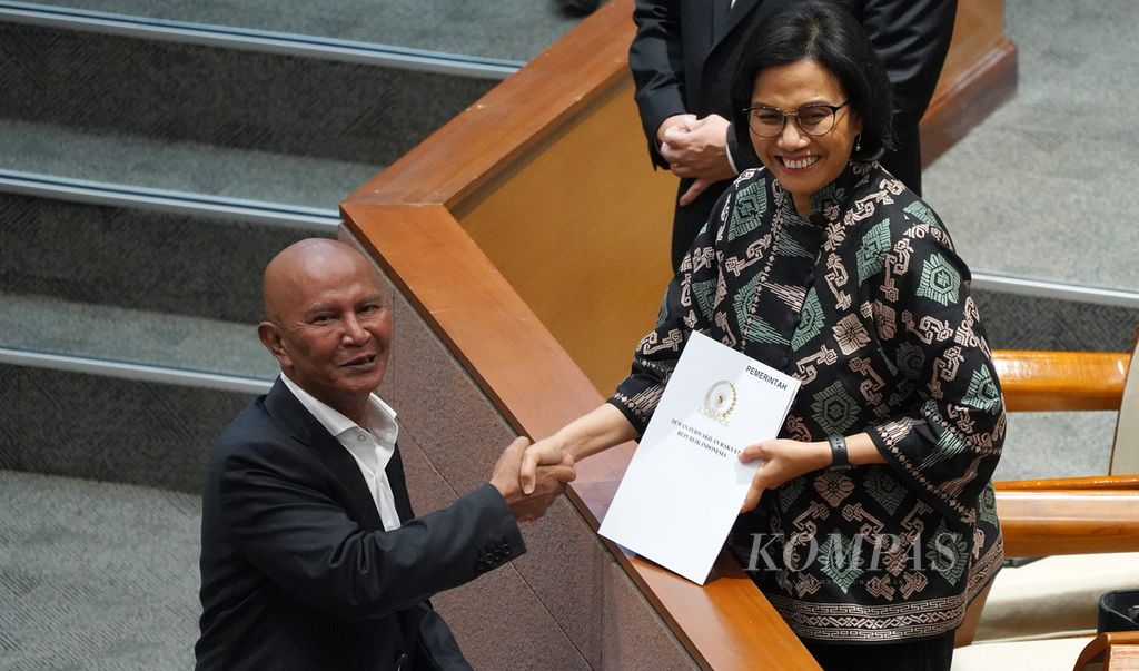 Ketua Badan Anggaran DPR Said Abdullah (kiri) menyerahkan UU APBN 2023 yang disahkan DPR kepada Menteri Keuangan Sri Mulyani saat Rapat Paripurna Ke-7 Masa Sidang 1 Tahun Sidang 2022-2023 di Ruang Sidang Paripurna DPR, Jakarta, Kamis (29/8/2022). 
