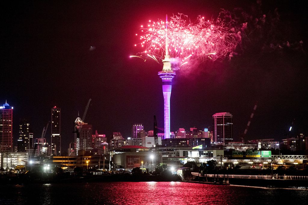 Kembang api menyala di atas Sky Tower di Auckland tengah saat perayaan Tahun Baru dimulai di Selandia Baru, Minggu, 1 Januari 2023. 