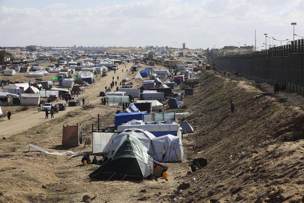 Warga Palestina yang terusir dari tempat tinggal asal mereka akibat serangan udara dan darat militer Israel di Jalur Gaza mendirikan tenda-tenda hunian di Rafah di dekat pagar perbatasan antara Mesir dan Gaza, 24 Januari 2024. 