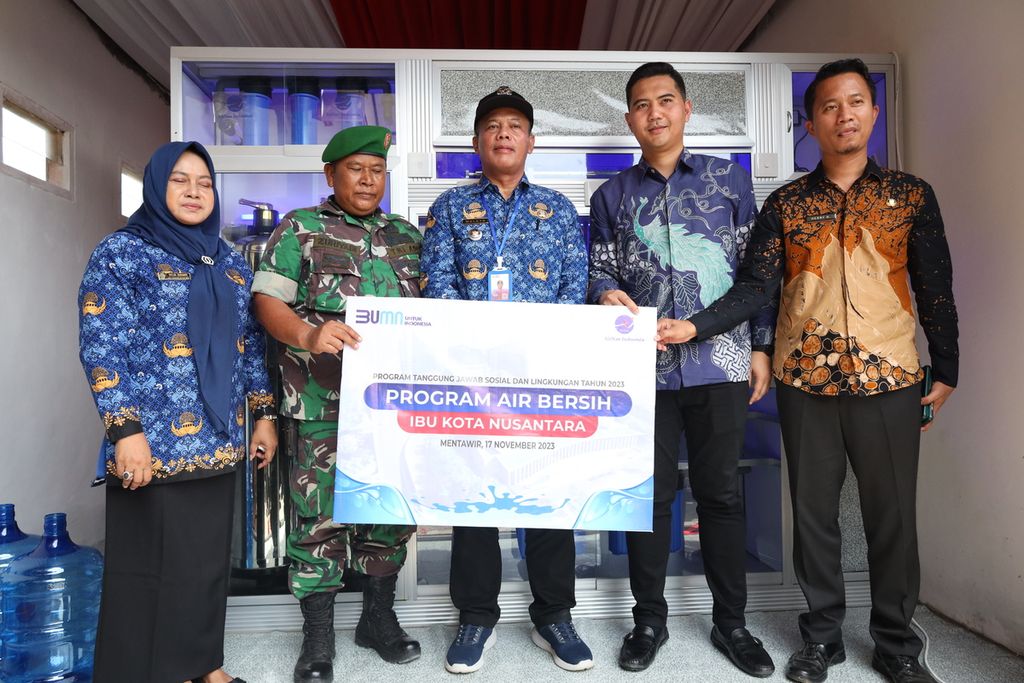 Perwakilan warga, pemerintah kelurahan, dan AirNav Indonesia berfoto di depan mesin penyuling air di Kelurahan Mentawir, Kecamatan Sepaku, Penajam Paser Utara, Kalimantan Timur, Jumat (17/11/2023).