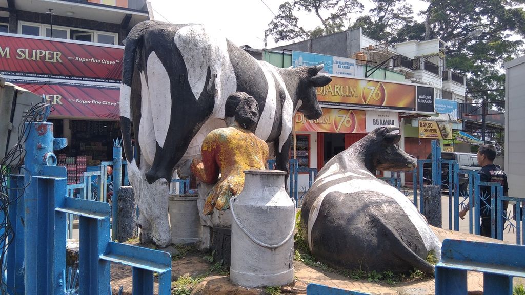 Patung peternak tengah memerah susu sapi menjadi salah satu ciri khas penanda daerah Pujon, di Kabupaten Malang, Jawa Timur. Pujon merupakan salah satu sentra sapi perah di Kabupaten Malang. Gambar diambil Senin (10/5/2021).