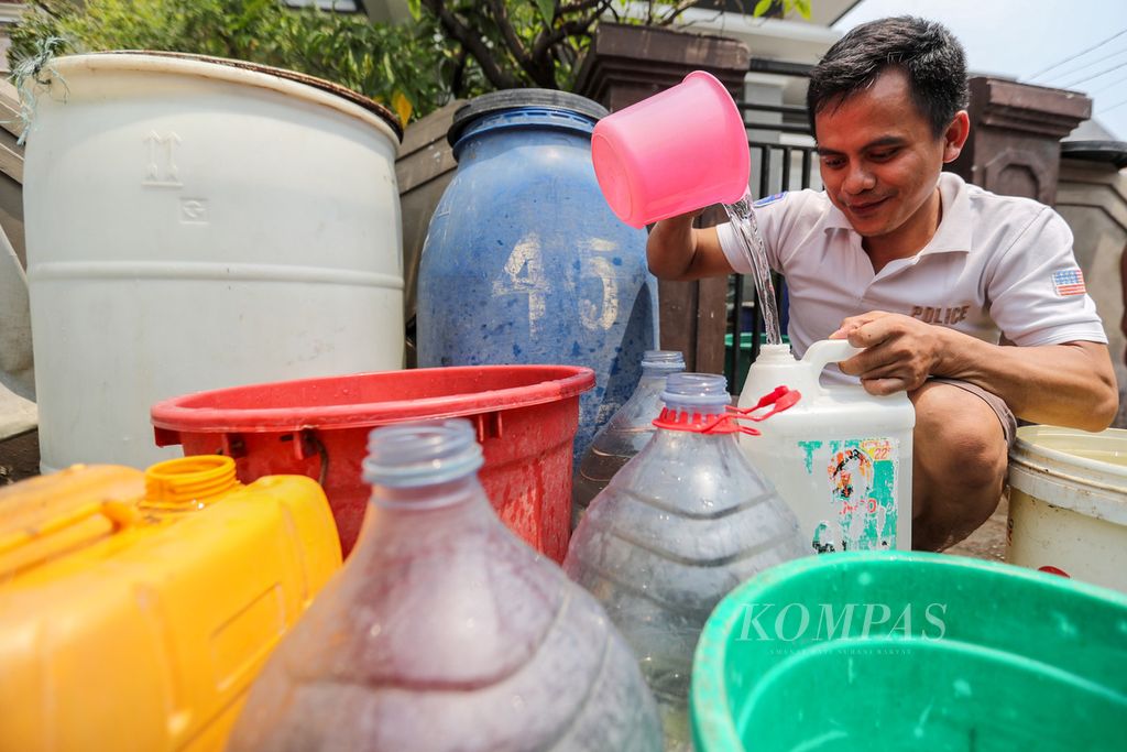 Warga membagi-bagi air ke wadah penampung air milik warga RW 011, Kecamatan Kalideres, Jakarta Barat, Kamis (14/9/2023). 