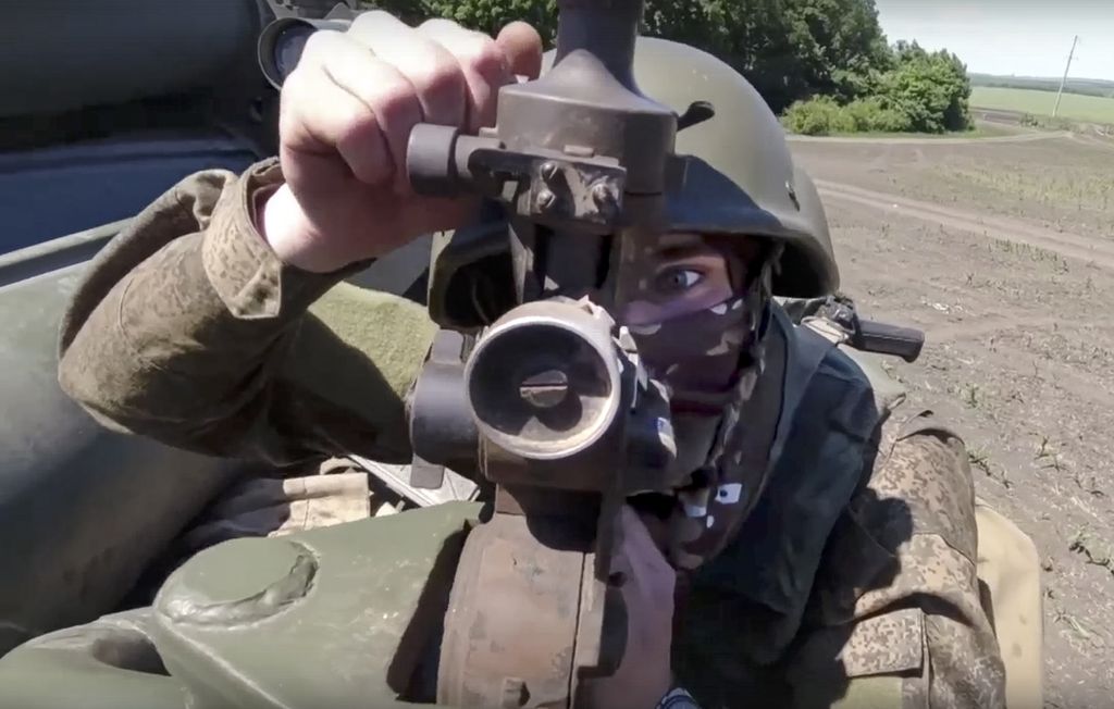 Seorang penembak dari sebuah satuan pasukan Rusia bersiap menembak ke arah sasaran tentara Ukraina di lokasi yang tidak disebutkan dalam foto yang dirilis Bagian Pers Kementerian Pertahanan Rusia, Sabtu (25/6/2022). 
