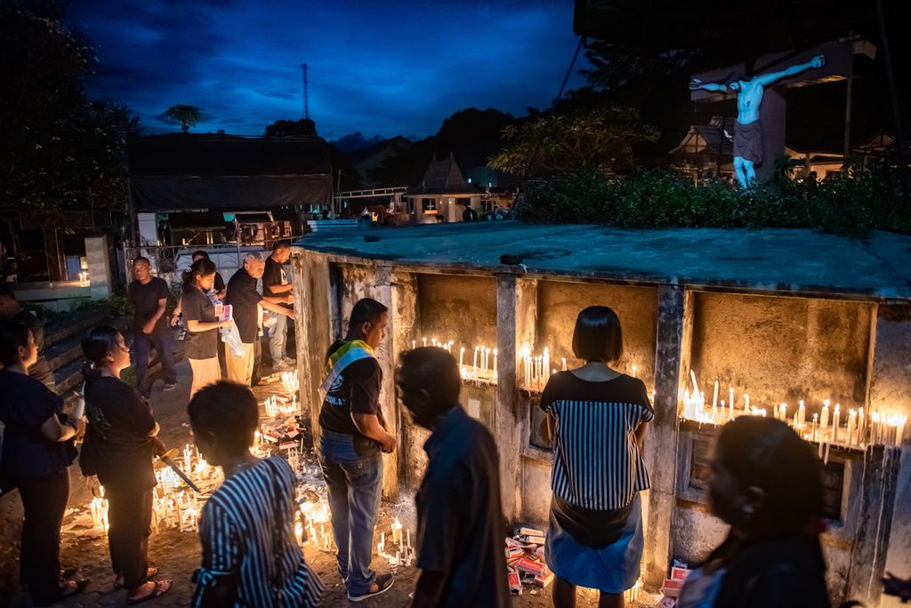 Hari Jumat Agung saat sore menuju malam, warga menyalakan lilin dan berdoa untuk kerabat dan para pemuka agama yang dimakamkan di pemakaman kota Larantuka.