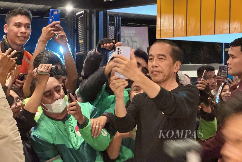 Presiden Joko Widodo berfoto dengan para pengemudi ojek daring di kedai Mie Gacoan di Kota Mataram, Nusa Tenggara, Selasa (30/4/2024) malam. Presiden berada di Lombok dalam rangka kunjungan kerja di Nusa Tenggara Barat.