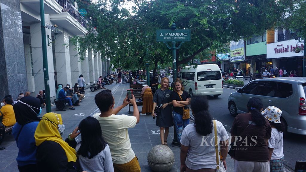  Tourists take pictures under the sign on Jalan Malioboro, Yogyakarta, Tuesday (3/5/2022). Tourist visits are getting busier after the 2022 Idul Fitri homecoming is allowed.