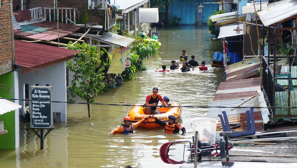 Proses evakuasi dari kampung terdampak banjir, di Kelurahan Pucangsawit, Kecamatan Jebres, Kota Surakarta, Jawa Tengah, Jumat (17/2/2023). Perkampungan tersebut berada di tepi Sungai Bengawan Solo. Namun, banjir lebih disebabkan oleh derasnya aliran kiriman sungai kecil di wilayah perkotaan.