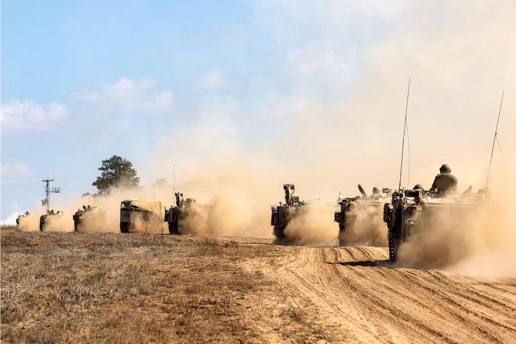 Tank-tank dan kendaraan militer Israel disiagakan di sepanjang perbatasan dengan Jalur Gaza di Israel selatan, 13 Oktober 2023. 