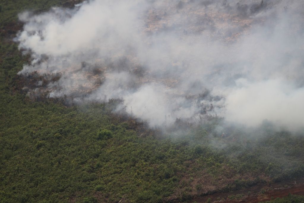 Pantauan kebakaran lahan terjadi di Kecamatan Sirah Pulau Padang, Kabupaten Ogan Komering Ilir, Sumatera Selatan, melalui helikopter bom air milik Badan Nasional Penanggulangan Bencana, Rabu (23/10/2019). 