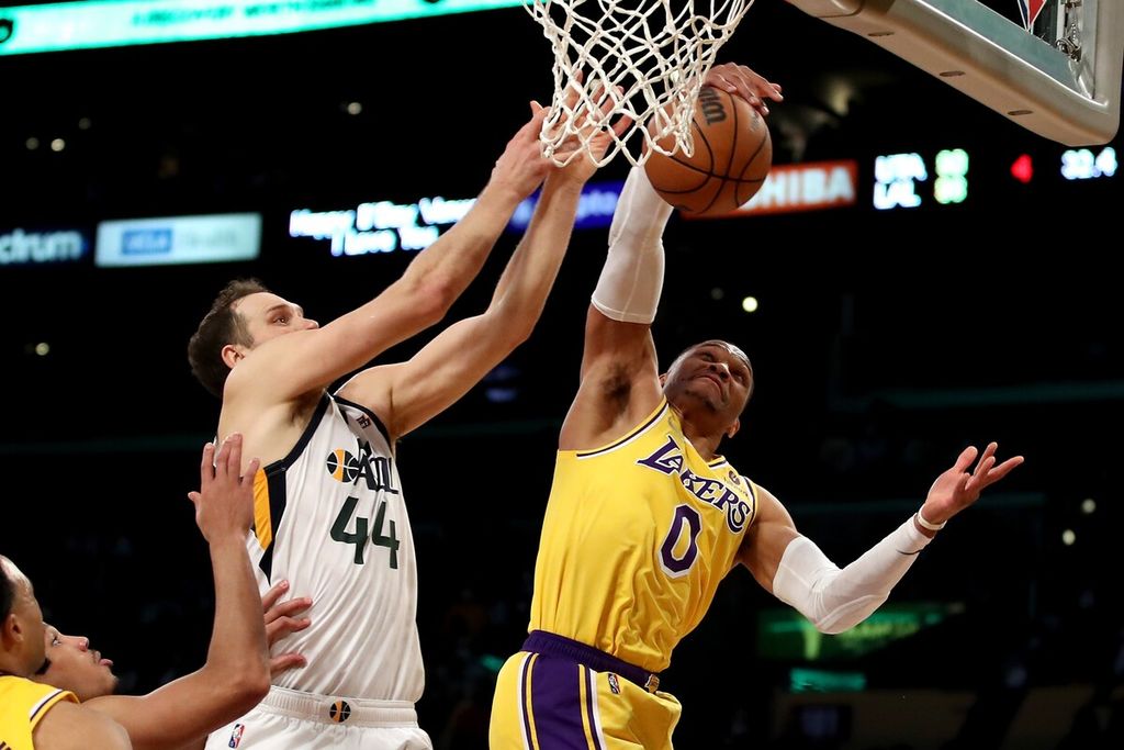 Pemain Los Angeles Lakers Russell Westbrook (kanan) dan pemain Utah Jazz Bojan Bogdanovic berebut bola saat melakukan rebound pada laga NBA di Arena Crypto.com, Los Angeles, Senin (17/1/2022)