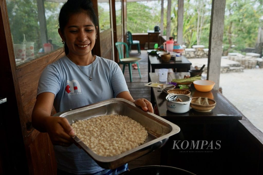 Musdalifah (40) menunjukkan <i>kaposu nosu</i>, hasil olahan jagung muda di Baubau, Sulawesi Tenggara, Rabu (22/11/2023). Masakan yang merupakan resep yang diturunkan selama bergenerasi ini disajikan dalam dokumentasi Pusaka Rasa Nusantara. 