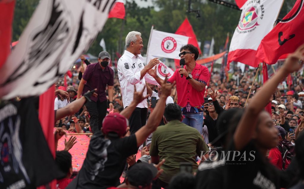Calon presiden nomor urut 3, Ganjar Pranowo, dan vokalis Slank, Kaka, dalam kampanye rapat terbuka Pemilihan Presiden 2024 di Alun-alun Kota Wates, Kulon Progo, DI Yogyakarta, Minggu (28/1/2024). 