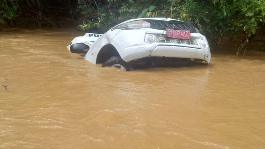 Sebuah kendaraan yang terdampak banjir di salah satu ruas jalan di Kabupaten Nabire, Papua, Kamis (29/9/2022).