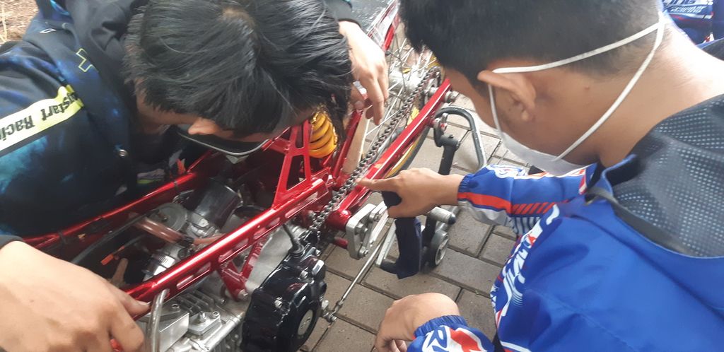 Mekanik motor balap modifikasi tengah mengecek motornya sebelum mengikuti latihan dalam acara Street Race Polda Metro Jaya, di Ancol, Pademangan, Jakarta Utara, Minggu (16/1/2022).