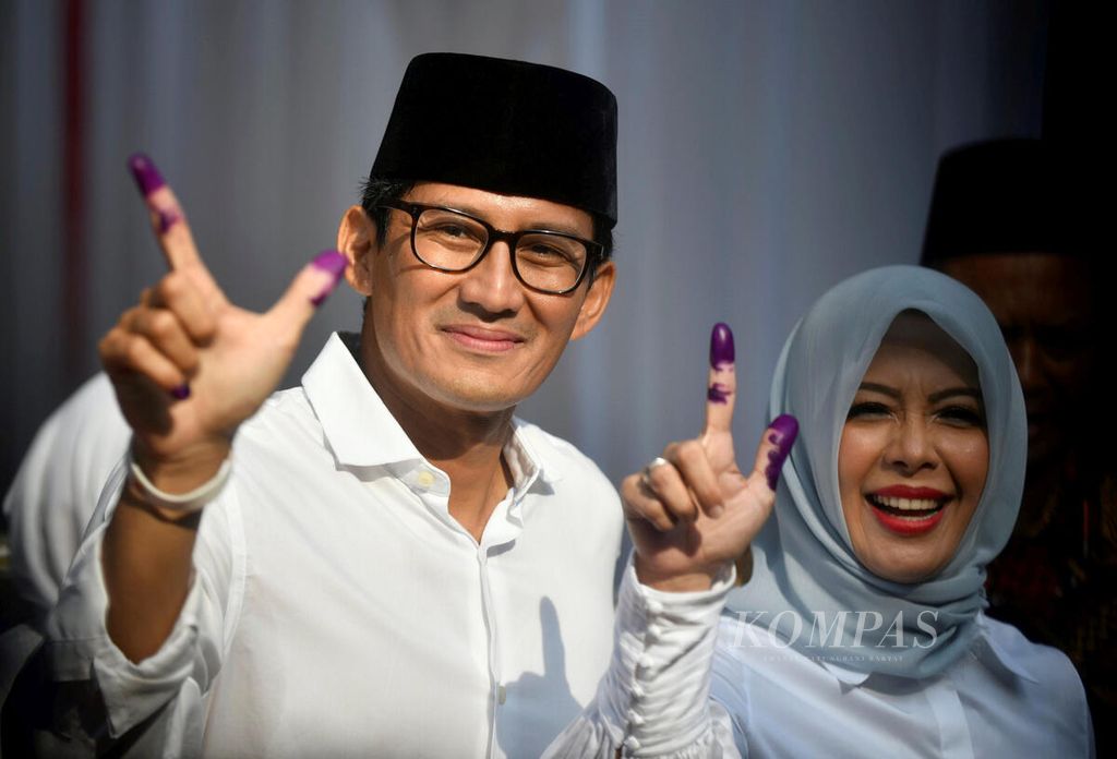 Cawapres Sandiaga Uno, didampingi istrinya, Nur Asia, memperlihatkan jari yang telah ditandai dengan tinta setelah memberikan hak pilihnya dalam Pemilu 2019 di TPS 02 Selong, Kebayoran Baru, Jakarta, Rabu (17/4/2019). 