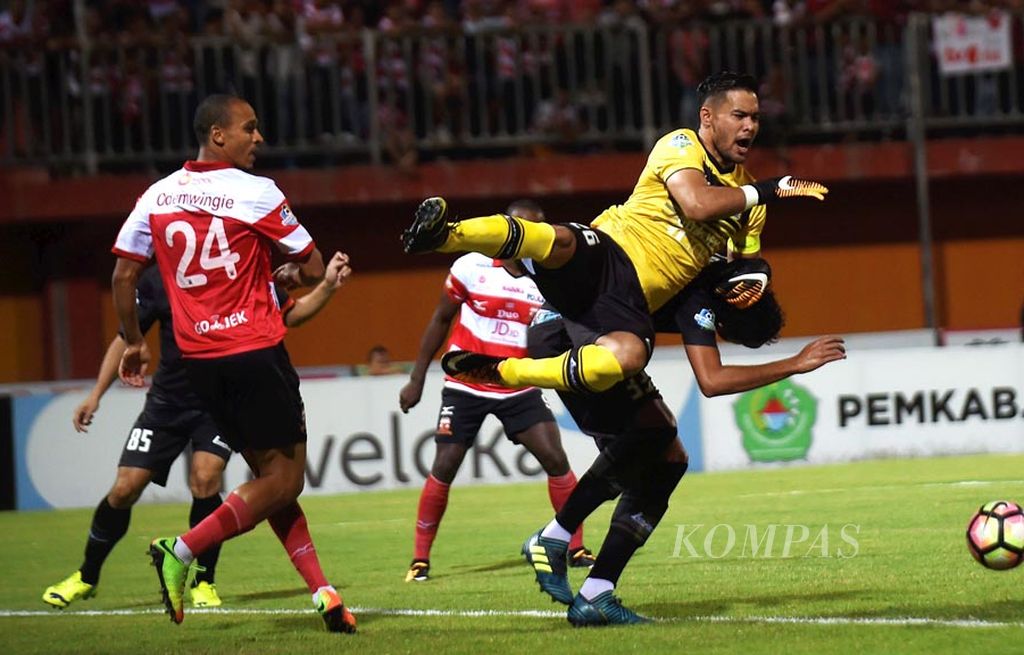 Penjaga gawang Persija Jakarta Andritany Ardhiyasa berusaha mengamankan bola saat melawan Madura United FC dalam Go-jek Traveloka Liga 1 di Stadion Ratu Pamelingan, Pamekasan, Senin (21/8). Pertandingan berakhir imbang 1-1.