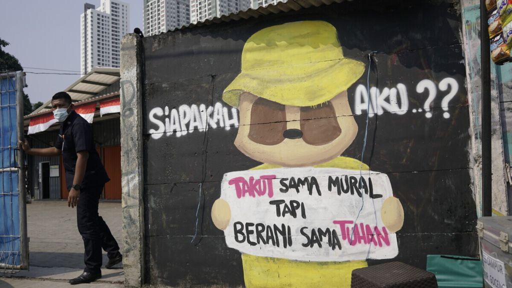 Warga melintasi kritikan terhadap penguasa di kawasan Tanah Abang, Jakarta Pusat, Kamis (9/9/2021). Kritik demokrasi harusnya dijadikan momentum memperbaiki birokrasi, bukan dibungkam dengan cara dihapus dan dihilangkan.