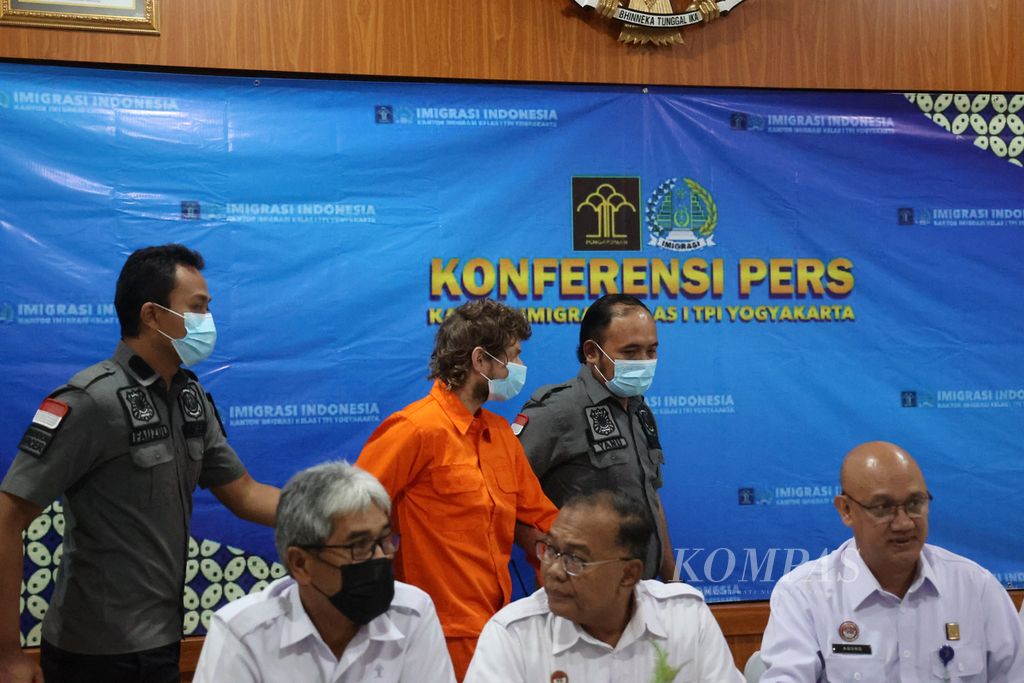 Warga negara Hongaria berinisial RS (berbaju oranye) digiring petugas saat acara konferensi pers terkait rencana deportasi dirinya di Kantor Imigrasi Kelas I TPI (Tempat Pemeriksaan Imigrasi) Yogyakarta, Sleman, Daerah Istimewa Yogyakarta, Rabu (5/4/2023). 