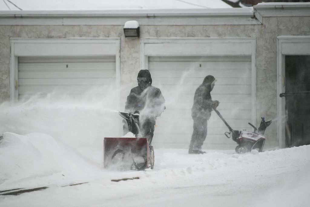 Warga sedang membersihkan lingkungan di sekitar jalan dan perumahan dari salju saat terjadi badai salju di Minneapolis, Minnesota, Rabu (22/2/2023). 