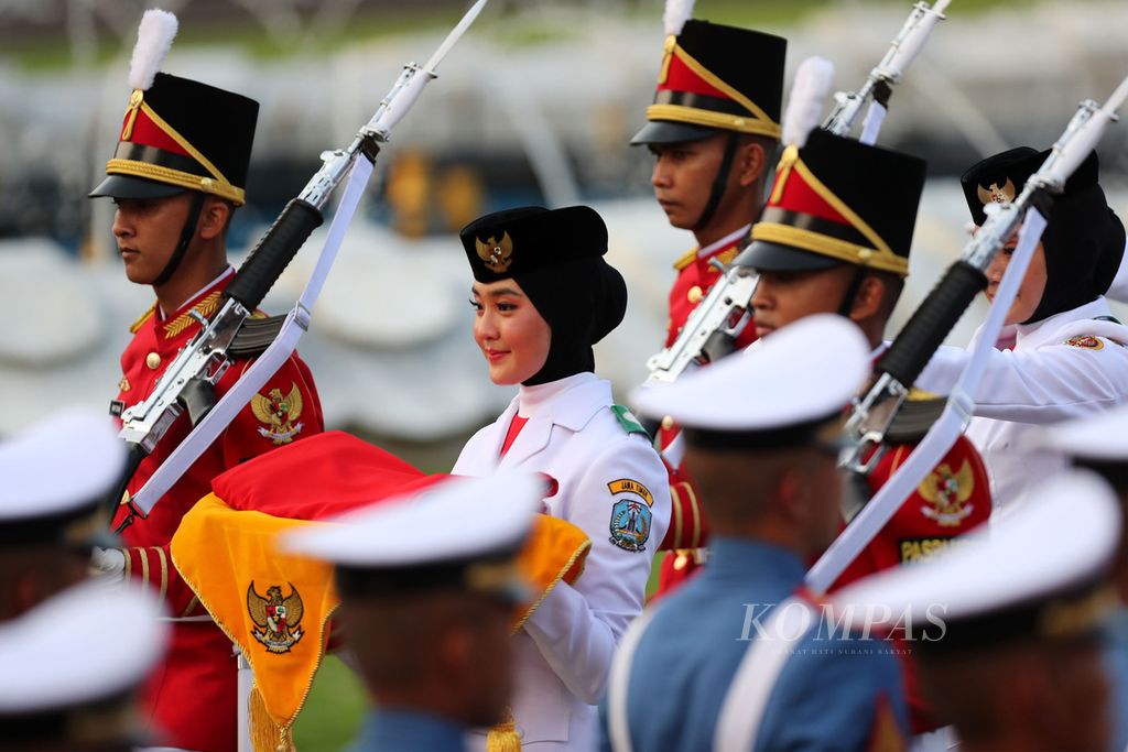 Ayumi Putri S, siswa SMAN 2 Taruna Bayangkara, Jawa Timur, membawa baki bendera Merah Putih dalam upacara penurunan bendera negara, Sang Merah Putih, di Istana Merdeka, Jakarta, Rabu (17/8/2022).  