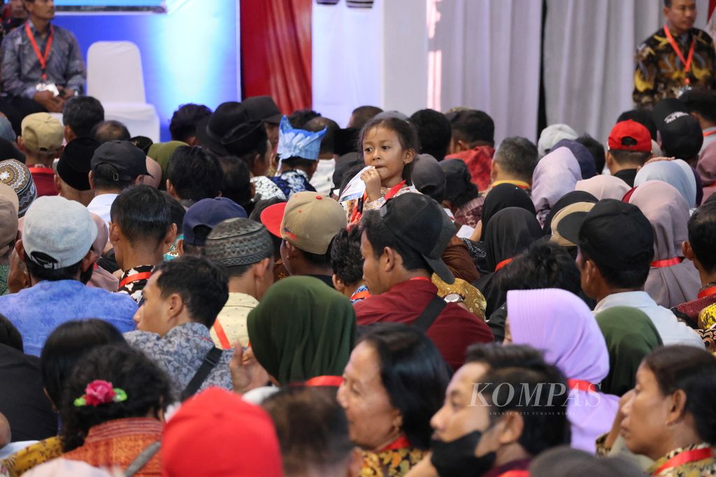 A child waits with their parents at GOR Tawangalun in Banyuwangi on Tuesday (30/4/2024) afternoon. Residents have been waiting for President Joko Widodo to distribute land certificates at the GOR since 11:00, while the President only arrived at 15:30.
