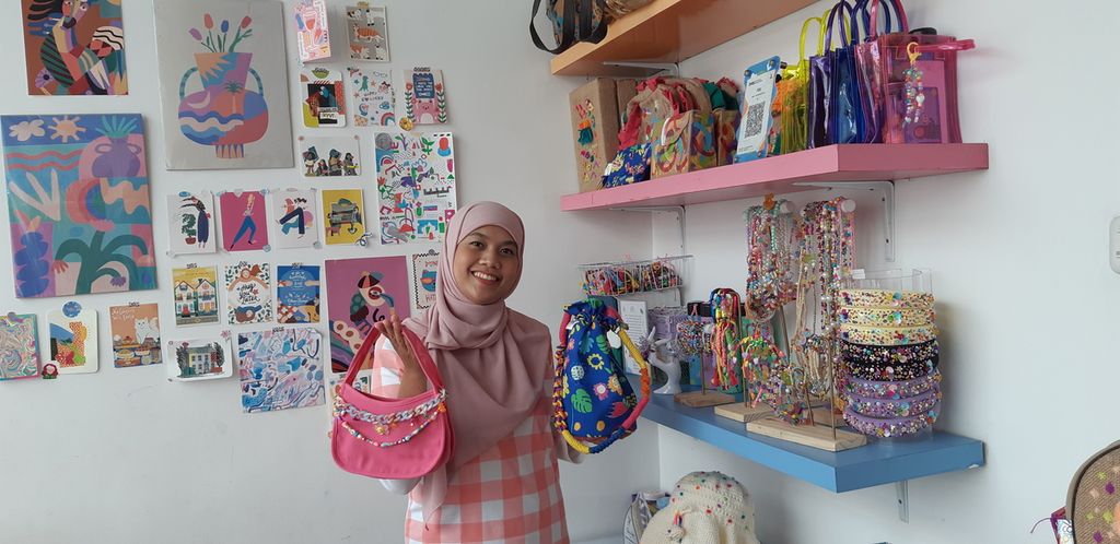 Dessy Nur Anisa Rahma memberdayakan difabel tuli dan wicara untuk berkarya membuat tas laptop dan aksesori dengan jenama Pulas Katumbiri atau Puka. Dessy berpose bersama produk Puka saat ditemui di Bandung pada Maret 2023.