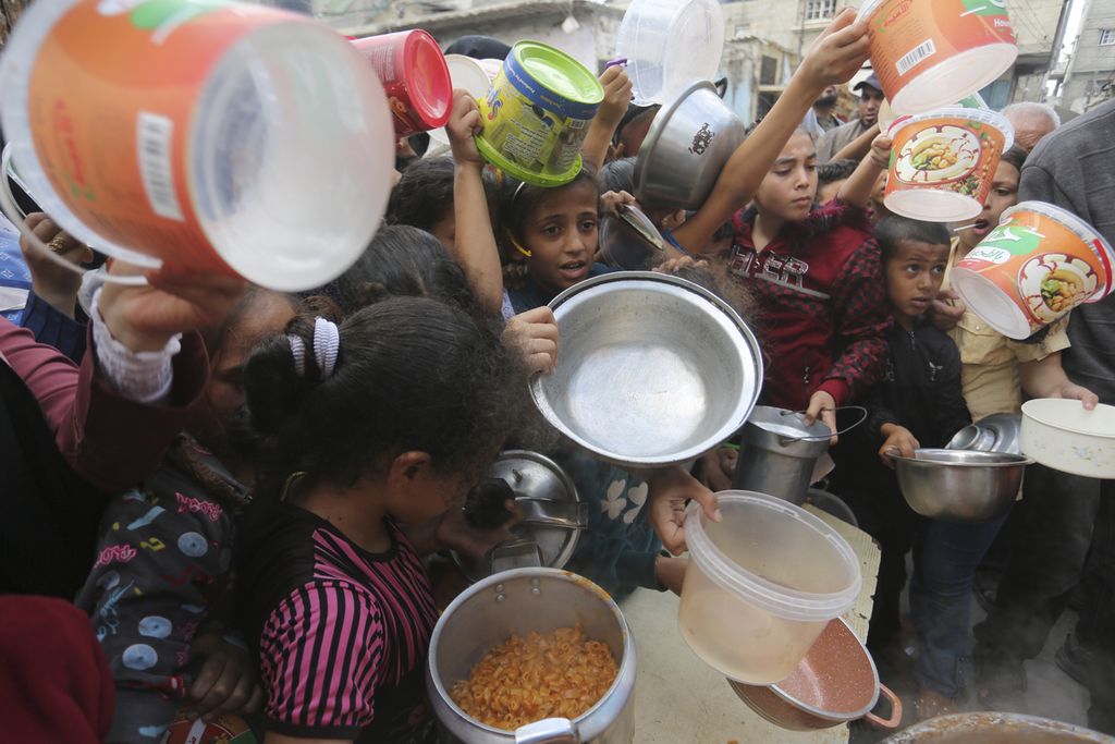 Warga Palestina antre mendapatkan makanan selama pengeboman Israel yang sedang berlangsung di Jalur Gaza di Rafah, Senin (13/11/2023).) 