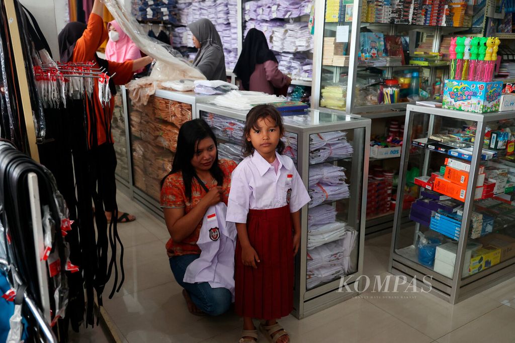 Salah satu anak mencoba seragam SD bersama ibunya di Krapyak, Kota Semarang, Jawa Tengah, Jumat (14/7/2023). Selesainya masa libur panjang sekolah membuat sebagian orangtua sibuk mencarikan kebutuhan perlengkapan anaknya untuk menyambut tahun ajaran baru. 