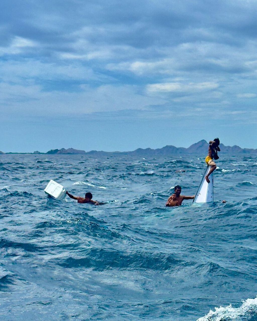 Acho (37) bersama keluarga bertahan di tengah laut ketika perahu mereka digulung gelombang di perairan Labuan Bajo, Kabupaten Manggarai Barat, Nusa Tenggara Timur, Minggu (30/6/2024).