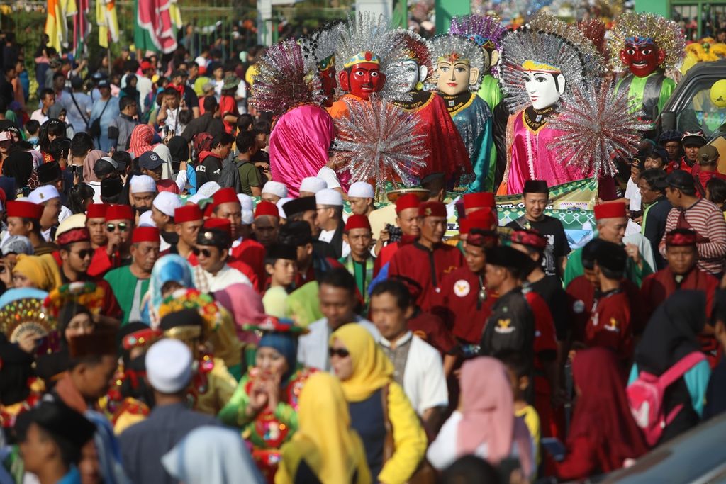 Arak-arakan ondel-ondel turut memeriahkan karnaval Lebaran Betawi melintasi Jalan Medan Merdeka Selatan, Jakarta Pusat menuju lapangan silang Monas saat berlangsung acara Lebaran Betawi (21/7/2019). 