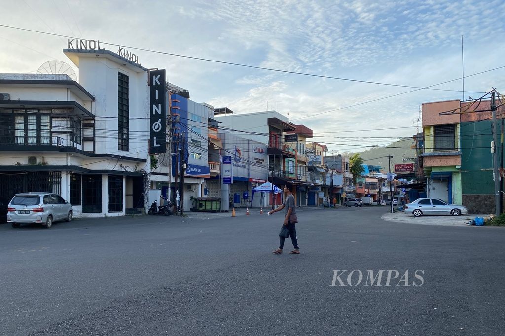 Seorang warga melintas di simpang kinol Kota Padang, Sumatera Barat, Jumat (16/6/2023) pagi. Pada malam hari, kawasan ini menjadi lokasi berburu kuliner bagi wisatawan yang datang ke kota tersebut.