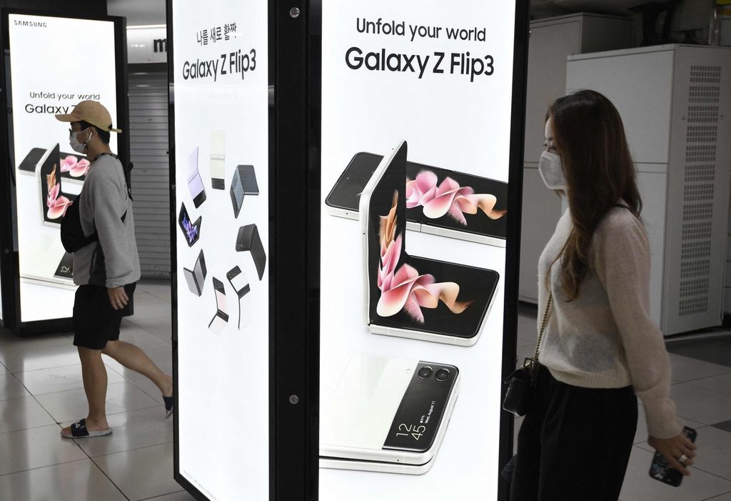 Warga berjalan melewati papan reklame elektronik telepon pintar Samsung Galaxy Z Fold3 dan Flip3 di sebuah pusat perbelanjaan bawah tanah di Seoul, Korea Selatan, 8 Oktober 2021.