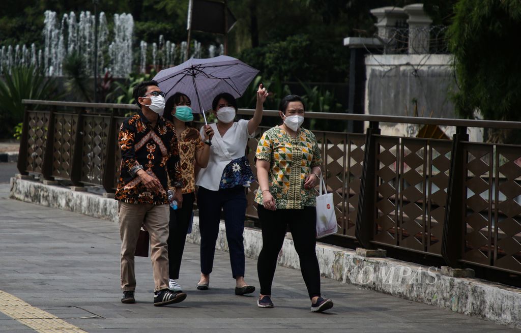Karyawan mengenakan masker saat istirahat siang di Jakarta, Kamis (10/8/2023).