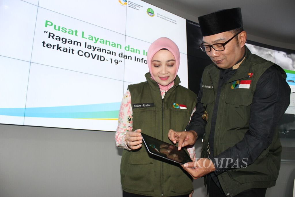 Gubernur Jawa Barat Ridwan Kamil bersama istrinya, Atalia Praratya, saat merilis aplikasi Pikobar di <i>command center,</i> Gedung Sate, Kota Bandung (20/3/2020)