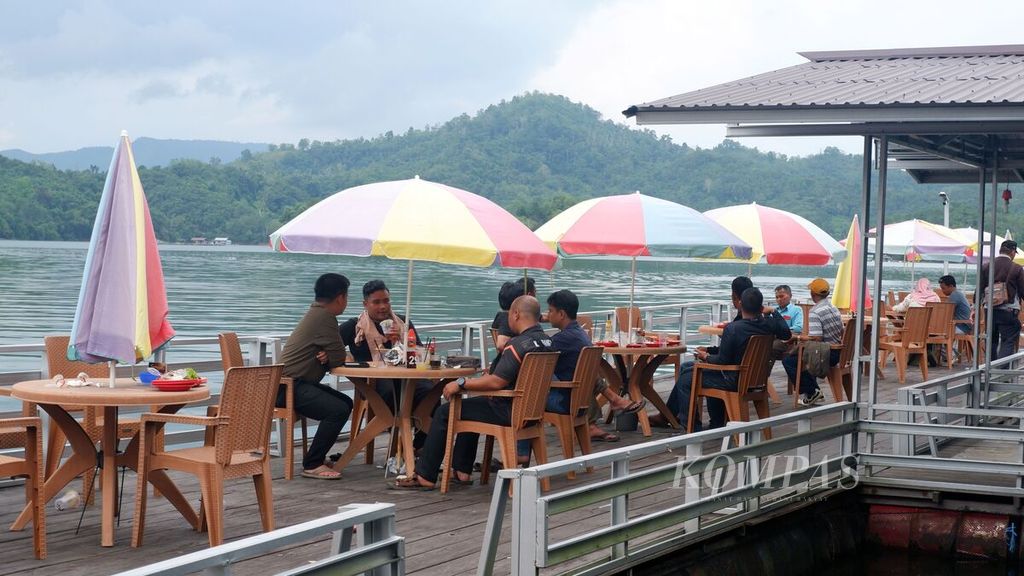 Pengunjung menikmati makanan dan minuman di rumah makan terapung di Waduk Riam Kanan, Desa Tiwingan Lama, Kecamatan Aranio, Kabupaten Banjar, Kalimantan Selatan, Sabtu (14/1/2023). 