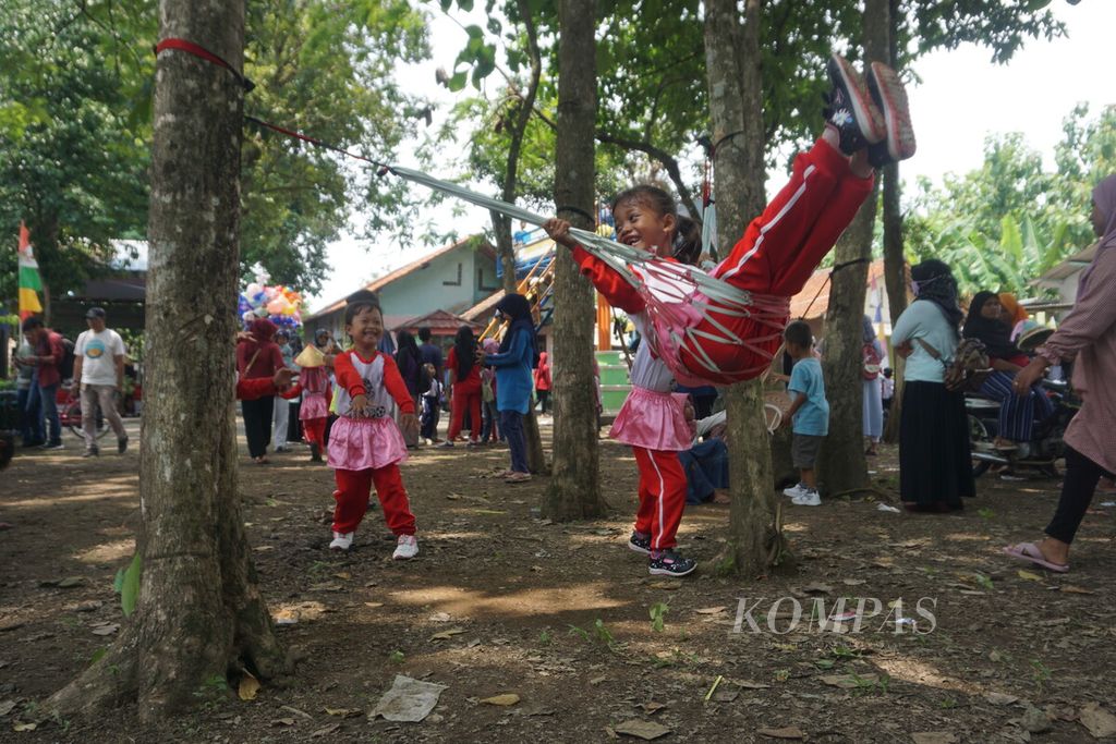 Anak-anak bermain ayunan <i>hammock</i> di Kampung Kreatif Karisma Pertamina di Desa Karangrena, Kecamatan Maos, Kabupaten Cilacap, Jawa Tengah, Rabu (28/2/2024).