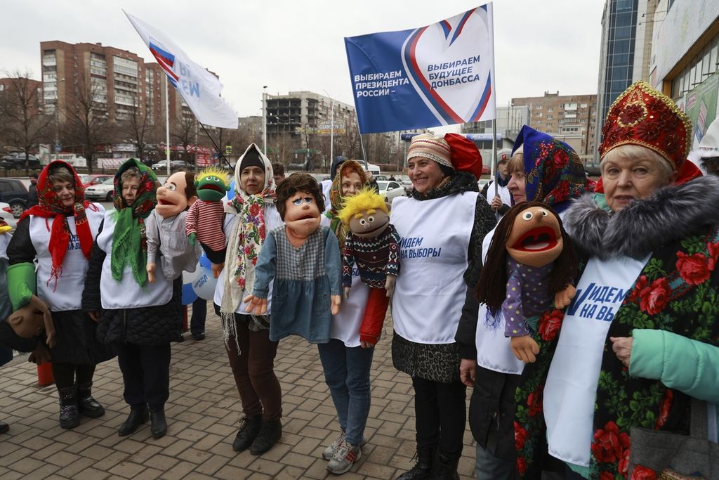 Sukarelawan dengan spanduk bertuliskan: Pilih presiden, pilih masa depan Rusia mempromosikan pemilihan presiden di Donetsk, ibu kota wilayah Donetsk, Ukraina, yang dikuasai Rusia, pada 14 Maret 2024. 