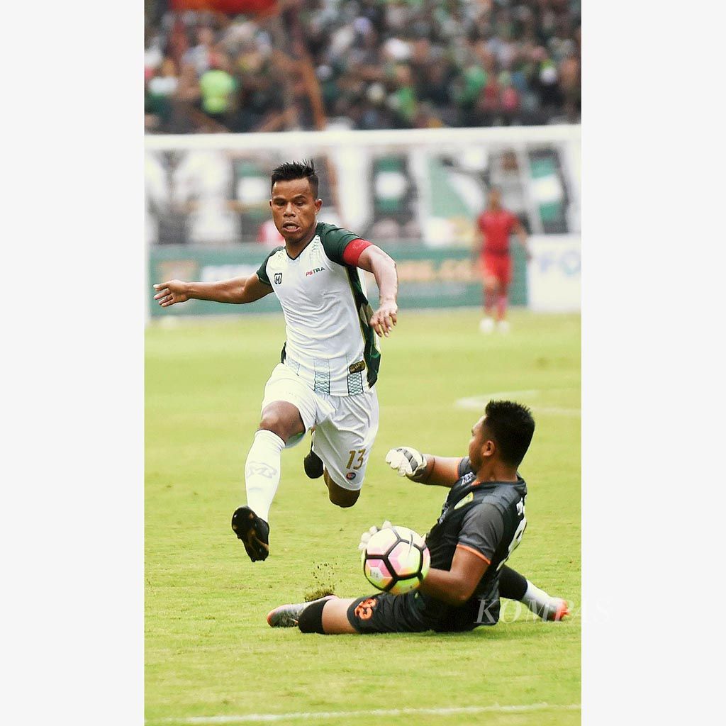 Pemain bertahan  PS TNI, Manahati Lestusen (kiri), berusaha melewati penjaga gawang Persebaya Surabaya, Dimas Galih Pratama, pada laga penyisihan Grup C Piala Presiden di Stadion Gelora Bung Tomo, Surabaya, Kamis (18/1). Pertandingan berakhir  1-1.