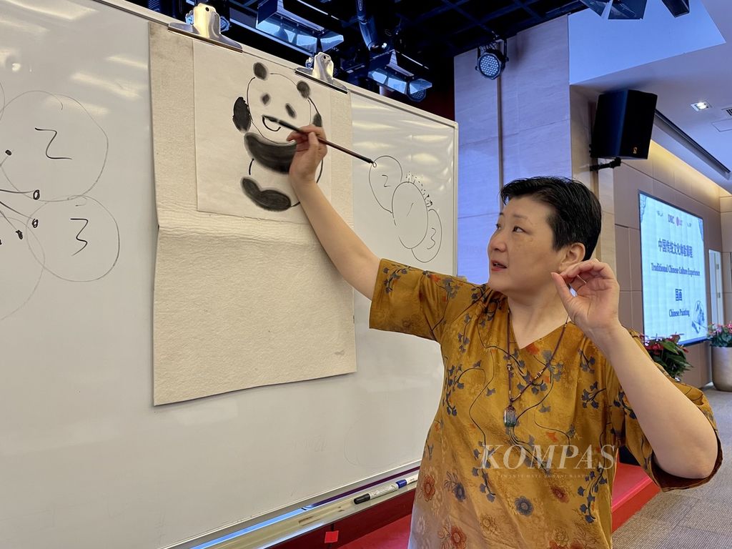 Seniman pelukis, Yu Danquing, sedang mengajarkan cara melukis panda dengan kuas tradisional China di Beijing, China, 4 Juli 2022.