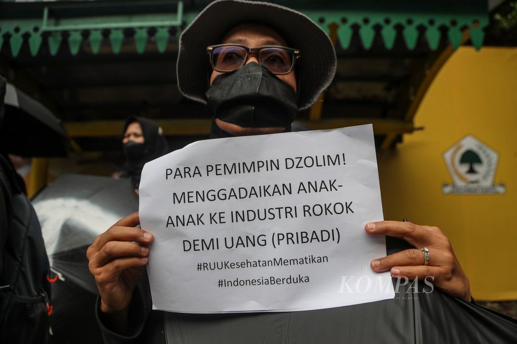 Peserta aksi membawa kertas bertuliskan rasa kecewa atas pengesahan UU Kesehatan dalam aksi di Jalan HR Rasuna Said, Jakarta Selatan, Jumat (14/7/2023). 