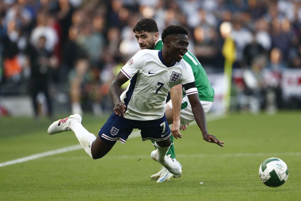 Pemain timnas Inggris, Bukayo Saka (depan), dijatuhkan oleh pemain Irlandia, Robbie Brady, pada laga Grup B2 Liga Nasional Eropa 2024-2025 di Stadion Aviva, Dublin, Sabtu (7/9/2024) dini hari WIB. Inggris menang 2-0 pada laga itu.