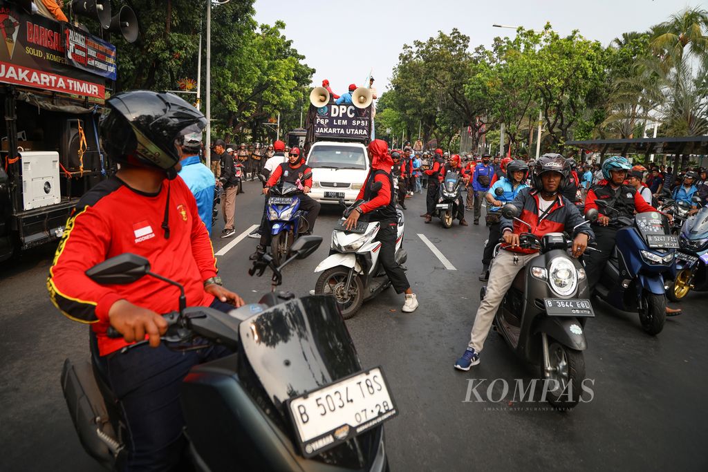 Massa buruh bersiap berpindah lokasi setelah dibubarkan oleh polisi di depan Balai Kota Jakarta, Selasa (21/11/2023).