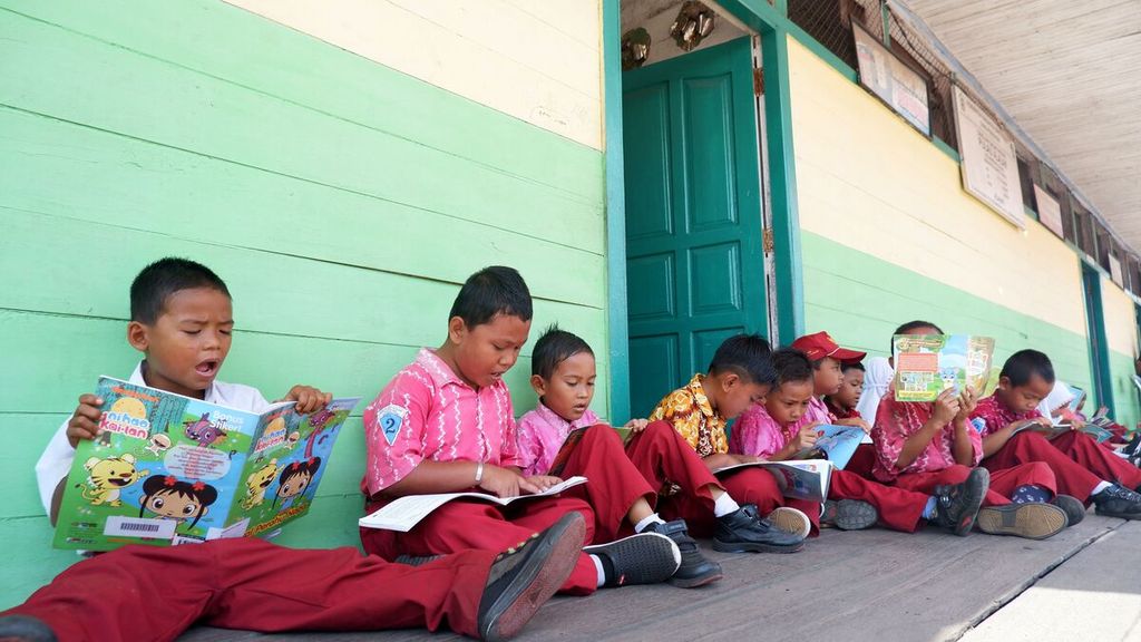 Siswa-siswi SD Negeri Pulau Alalak membaca buku bacaan dari motor trail perpustakaan keliling yang menyambangi sekolah mereka di Desa Pulau Alalak, Kecamatan Alalak, Kabupaten Barito Kuala, Kalimantan Selatan, Kamis (22/8/2019).